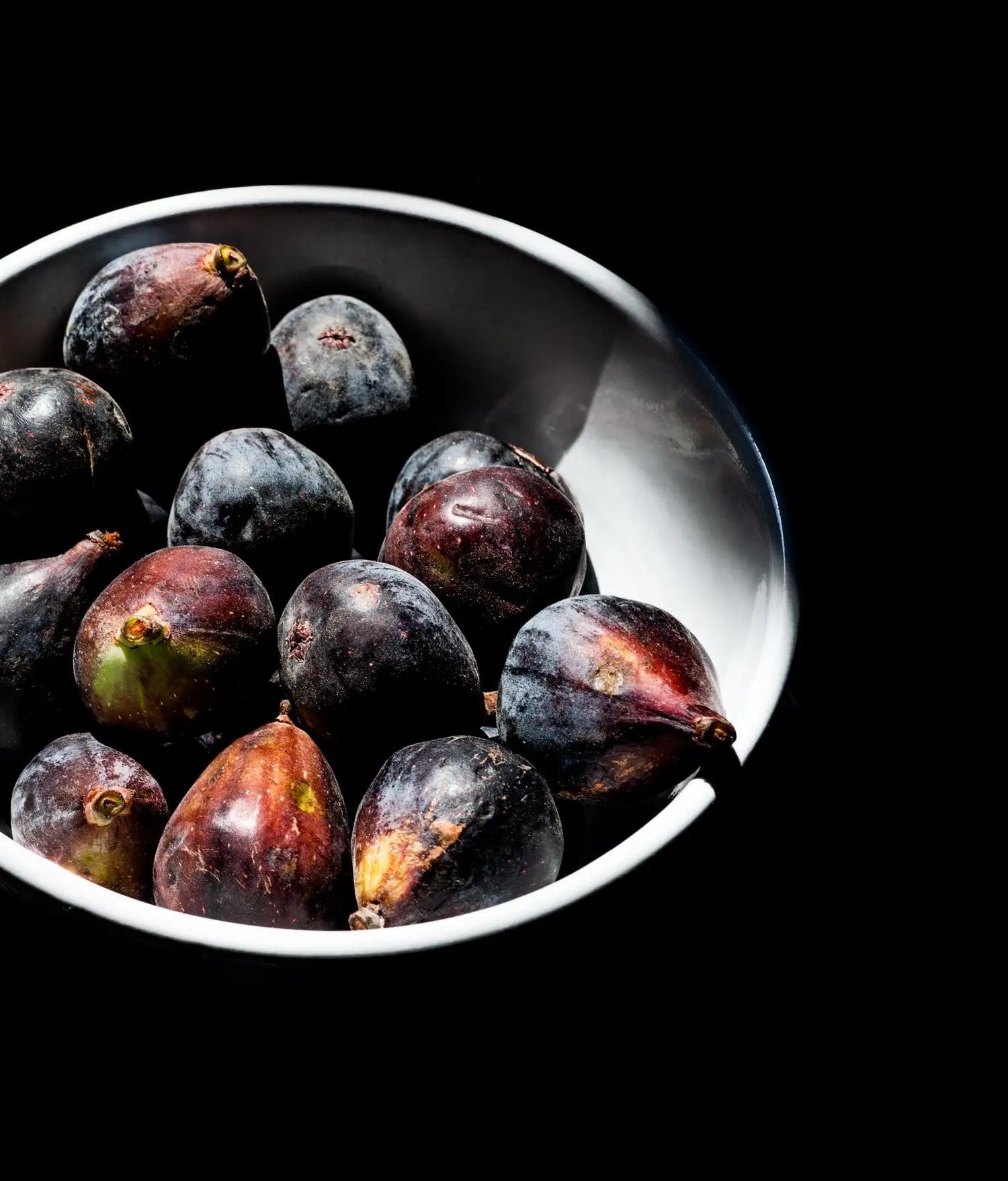Black figs in a white bowl.