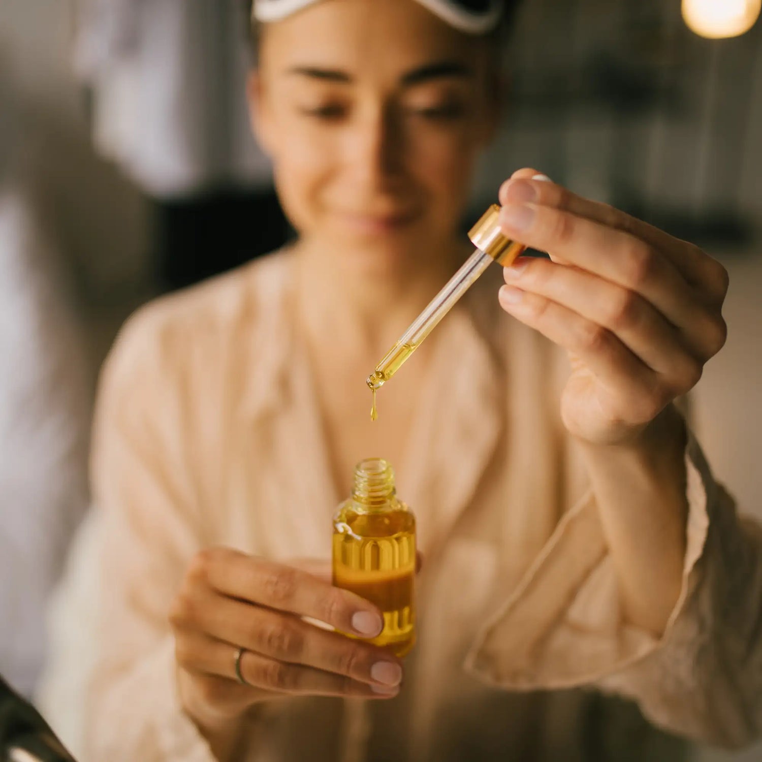 Golden amber liquid in a clear glass dropper bottle with a gold-toned cap.