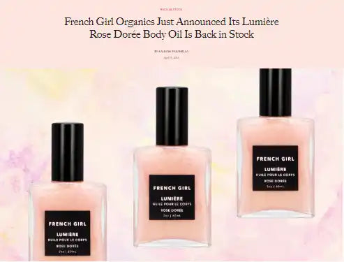 Three bottles of rose-colored body oil with black caps.